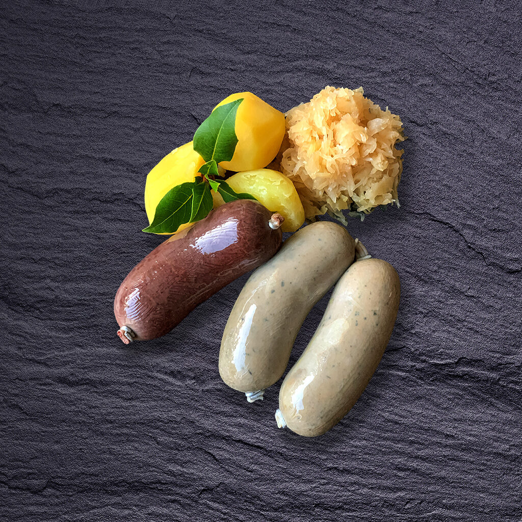 „Blutsbrüder“ Frische Berliner Blutwurst und „Ehrliche“ Leberwurst mit Salzkartoffeln und Sauerkraut auf dunkler Schieferplatte